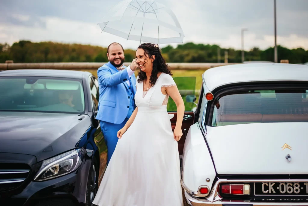 Sortie de voiture d'une mariée sous la pluie le jour de son mariage