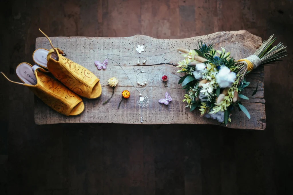 Bijoux de mariage, fleurs séchées, bouquet de mariée et chaussures pour une photo flat lay qui résume les préparatifs du mariage
