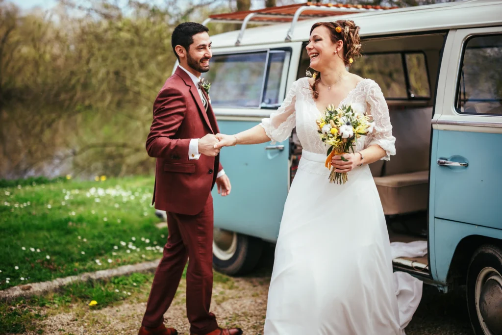 Femme en robe de mariée sortant du combi pour son mariage vintage